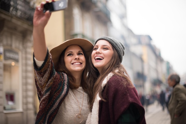 Mulheres jovens na moda tirando selfies na cidade