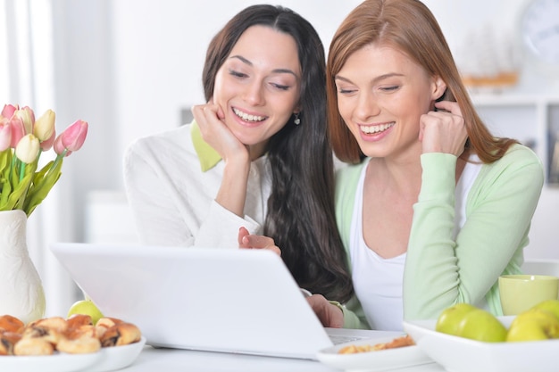 Mulheres jovens olhando para laptop