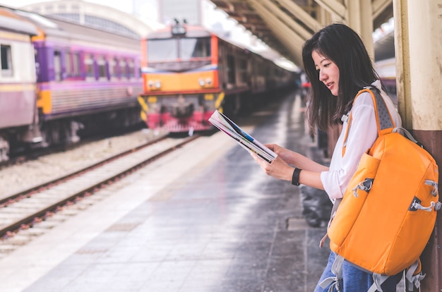 Mulheres jovens segurar mapa na mão na estação de trem