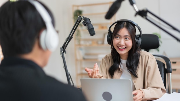 Mulheres jovens usando laptop e microfone para entrevistar o homem convidado e gravar para podcast de áudio