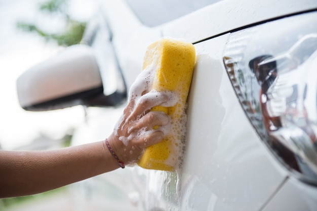 mulheres lavando carro com esponja amarela