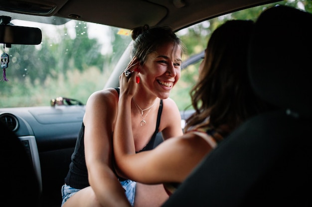 Mulheres lésbicas a abraçar-se enquanto estão sentadas no carro.