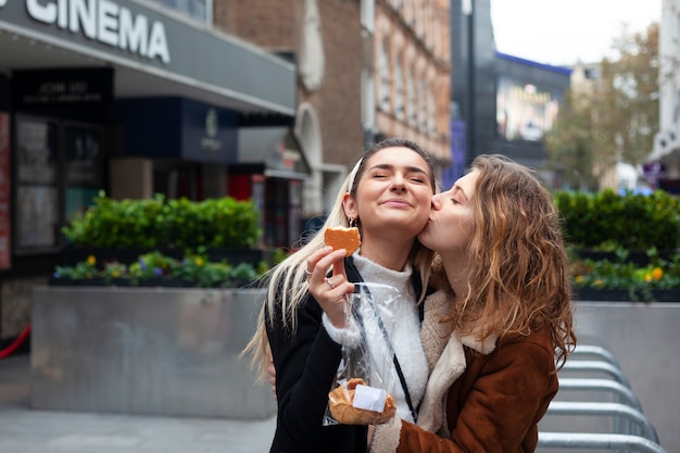 Foto mulheres lésbicas adoráveis se beijando ao ar livre