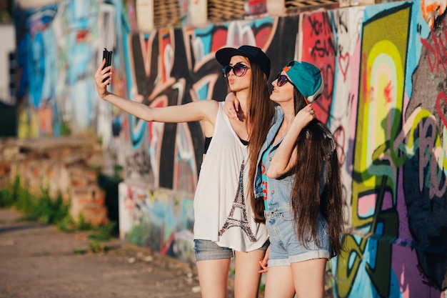 Mulheres levando selfie em graffiti