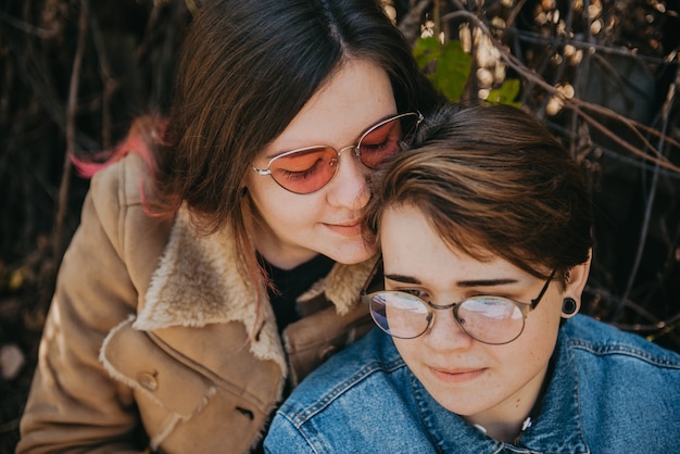 Foto mulheres lgbt. jovem casal de lésbicas caminhando juntos no parque. relacionamento delicado. foco seletivo