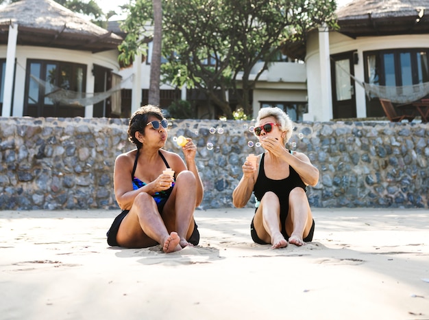 Mulheres maduras de bronzeamento na praia