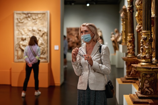 Mulheres maduras observando artes no museu. Excursão com grupo