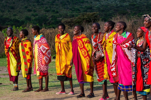 Mulheres Masai Mara em suas roupas tradicionais coloridas dançando juntas. Masai Mara, Quênia