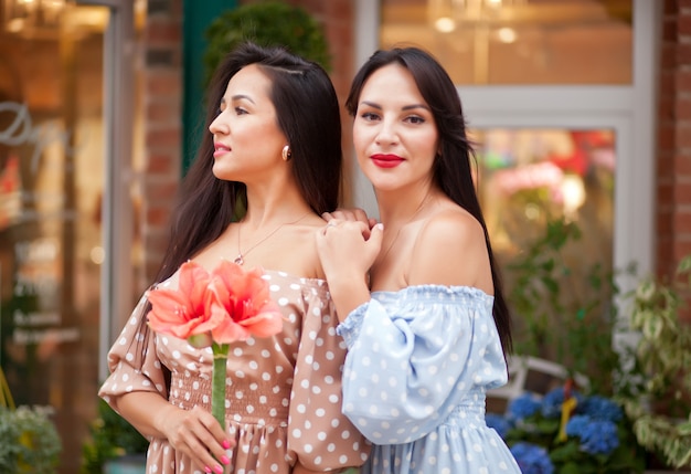 Mulheres morenas felizes bonitas novas que estão e que sorriem para se.