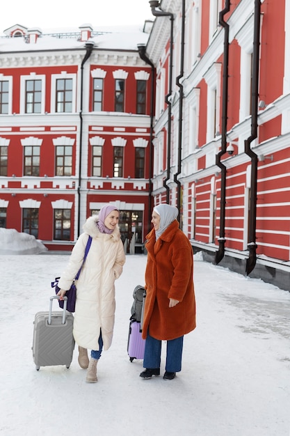 Foto mulheres muçulmanas caminhando com sua bagagem para o hotel enquanto estavam de férias