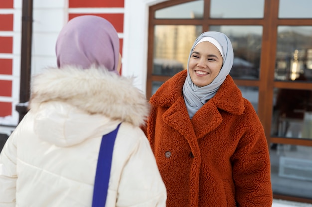 Mulheres muçulmanas com hijabs conversando e explorando a cidade enquanto estão de férias