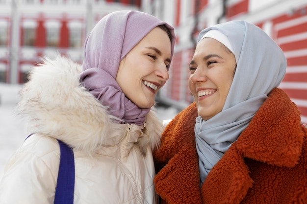 Mulheres muçulmanas com hijabs sorrindo e explorando a cidade enquanto estão de férias