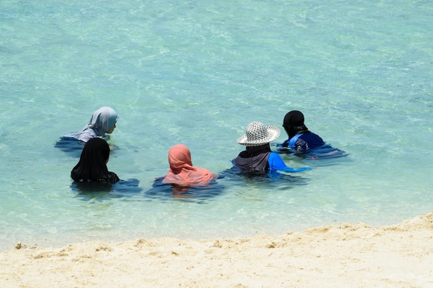 Mulheres muçulmanas em uma praia paradisíaca