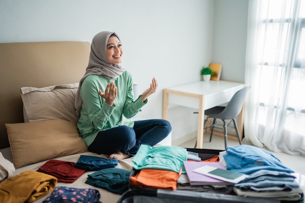 Mulheres muçulmanas rezando com a cama cheia de roupas