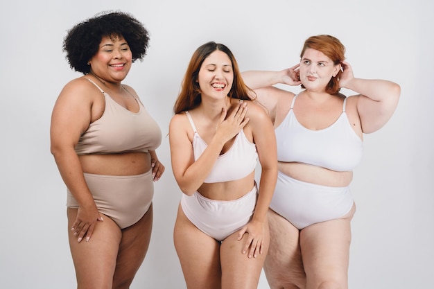 mulheres multi-raciais felizes latinas sorrindo em roupa interior fundo branco