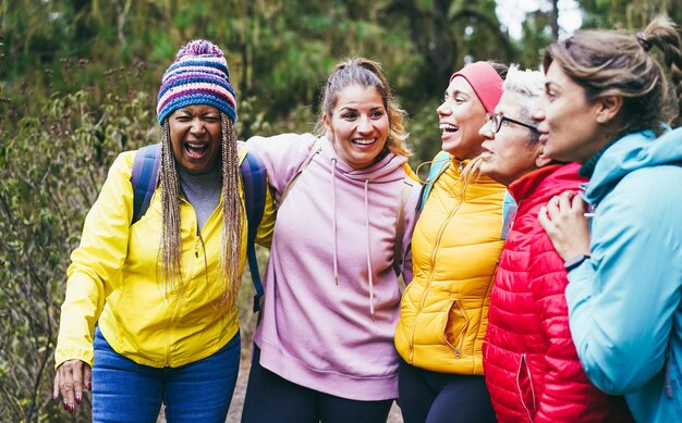 Foto mulheres multirraciais se divertindo durante o dia de trekking na floresta montanhosa concentre-se no chapéu feminino africano