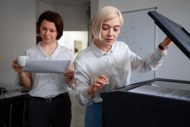 Mulheres no trabalho no escritório usando impressora