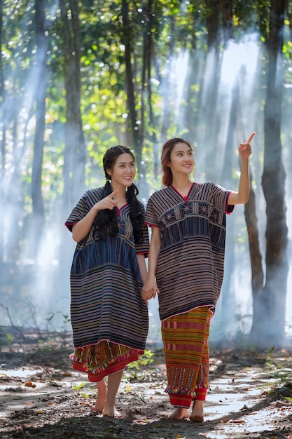 Mulheres novas de Karen que sorriem na floresta Tailândia local