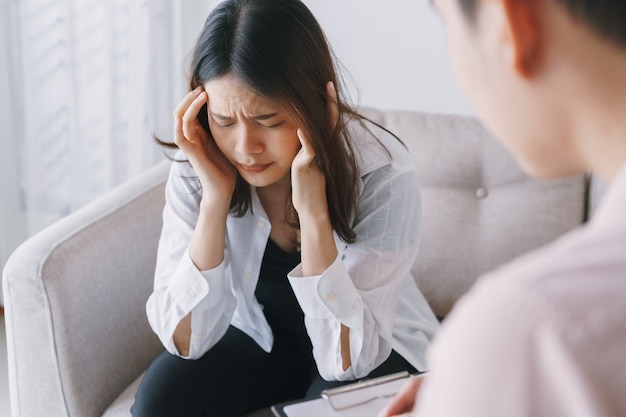 Mulheres pacientes asiáticos com consultoria de exame psicólogo homem