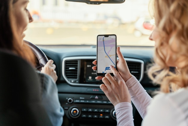 Mulheres procurando um local no mapa do telefone