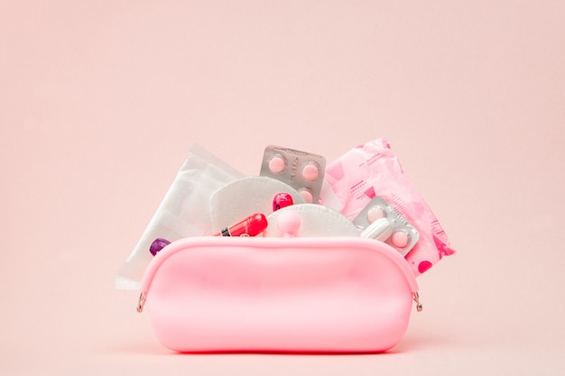 Foto mulheres produtos de higiene íntima - absorventes e tampões na parede rosa, cópia espaço. conceito do período menstrual. vista superior, configuração plana, cópia espaço