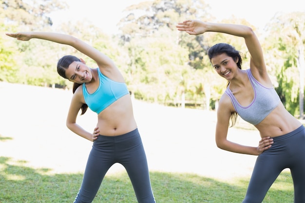 Mulheres que se estendem no parque