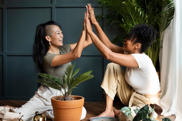 Mulheres repotting plantas em casa no novo normal