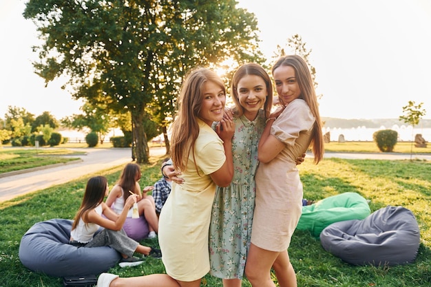 Mulheres se abraçando Grupo de jovens faz uma festa no parque durante o dia de verão
