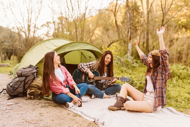 Foto mulheres se divertindo perto da tenda