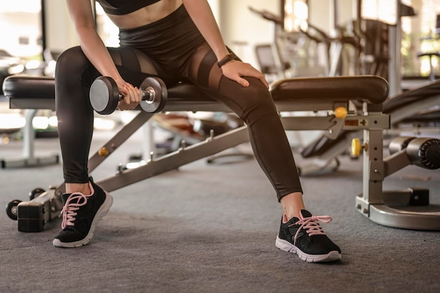 Mulheres se exercitam por halteres no ginásio coberto para uma boa saúde ao pôr do sol. fitness, treino, ginástica, estilo de vida e conceito saudável.