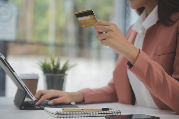 Mulheres segurando cartão de crédito e usando smartphones em casaCompras on-line internet banking loja pagamento on-line gastar dinheiro pagamento de comércio eletrônico na loja conceito de cartão de crédito