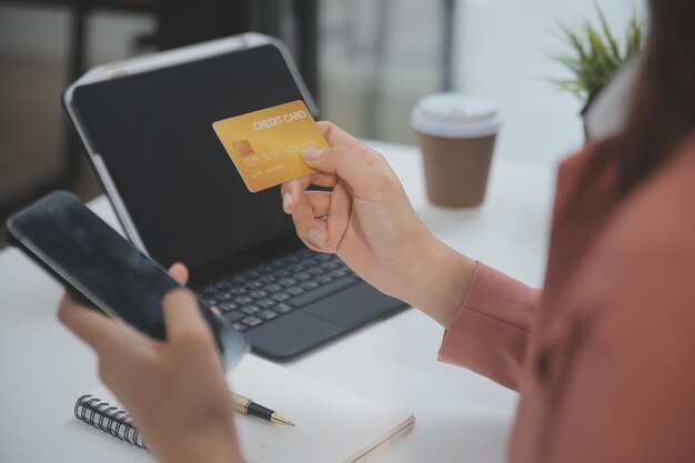 Mulheres segurando cartão de crédito e usando smartphones em casaPagamento on-line da loja de serviços bancários on-line, gastando dinheiro, pagamento de comércio eletrônico no conceito de cartão de crédito da loja