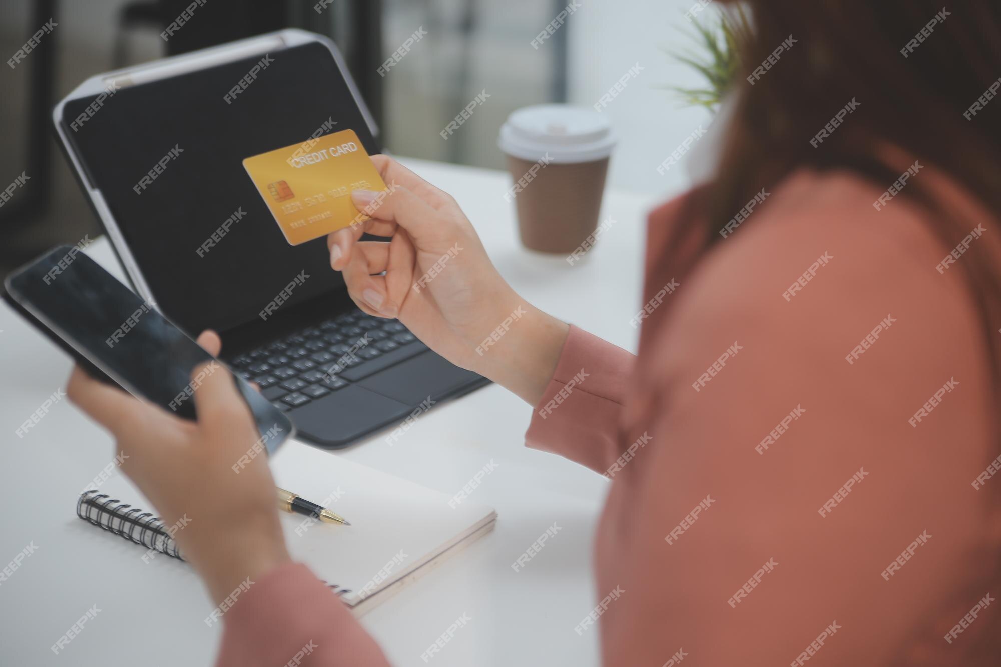 close-up de garota negra segurar o cartão de crédito do banco e digitar no  laptop