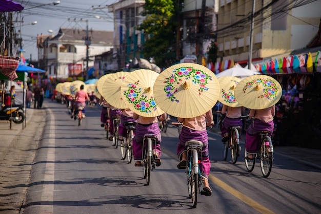 Mulheres segurando guarda-sóis bonitos e show de ciclismo no Bosang guarda-chuva festi val Chiang Mai, Tailândia