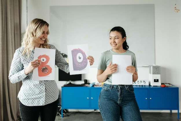 Mulheres segurando papéis com letras de arte Foto de estoque