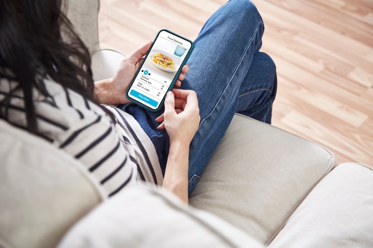 Foto mulheres segurando um telefone com aplicativo entregando comida online