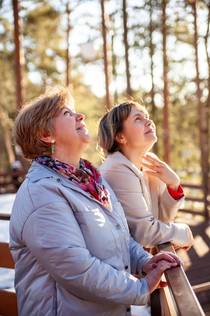 Mulheres sênior casuais contemplativas andando na primavera parkxDxA