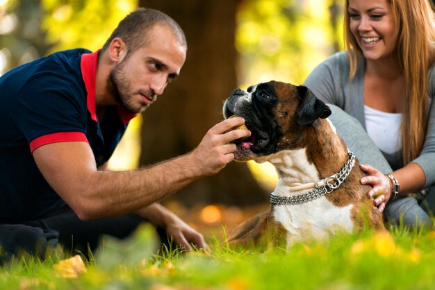 Mulheres sentadas ao ar livre com seu cão de estimação boxer alemão