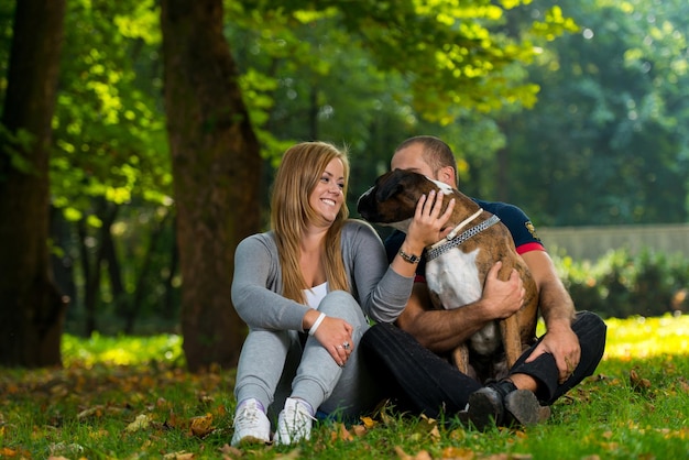 Mulheres sentadas ao ar livre com seu cão de estimação boxer alemão