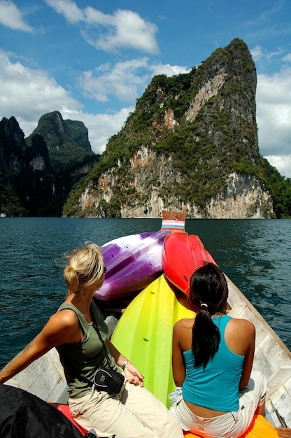 Mulheres sentadas em um barco no lago contra as montanhas