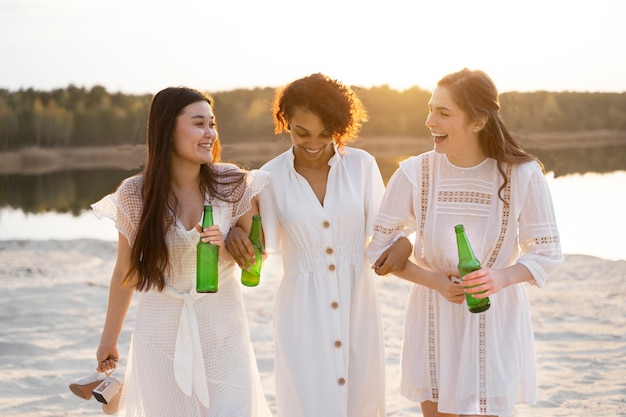 Foto mulheres sorridentes de tiro médio com bebidas