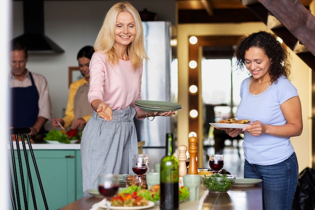 Mulheres sorridentes de tiro médio com comida