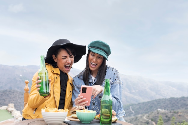 Foto mulheres sorridentes de tiro médio com smartphone