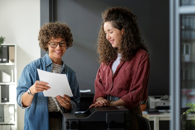 Foto mulheres sorridentes de tiro médio no trabalho