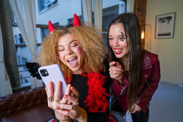 Mulheres sorridentes de tiro médio tomando selfie