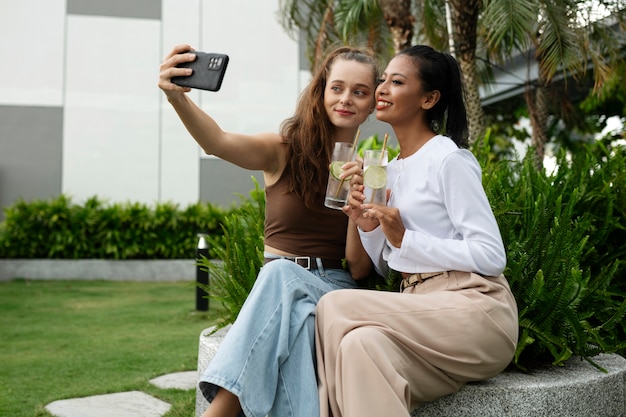 Foto mulheres sorridentes de vista lateral tomando selfie