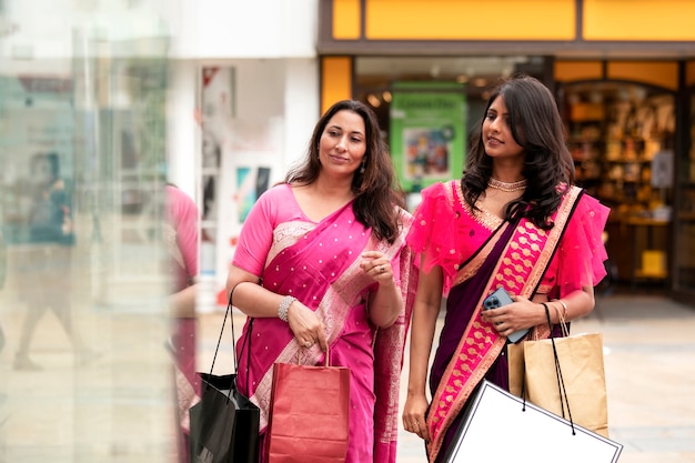 Mulheres sorridentes em tiro médio com sacolas de compras