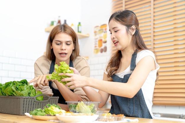 Mulheres sorridentes preparando saladas frescas e saudáveis mulher sentada na despensa em uma bela cozinha interior A comida de dieta limpa de produtos e ingredientes locais Mercado fresco