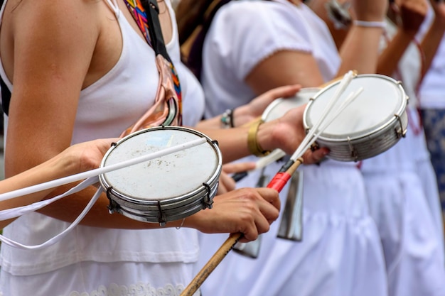 Mulheres tocando tamborim nas ruas do Brasil durante uma apresentação de samba