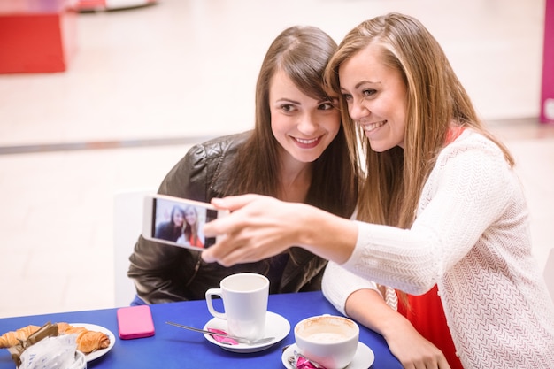 Mulheres tomando uma selfie enquanto tomando café